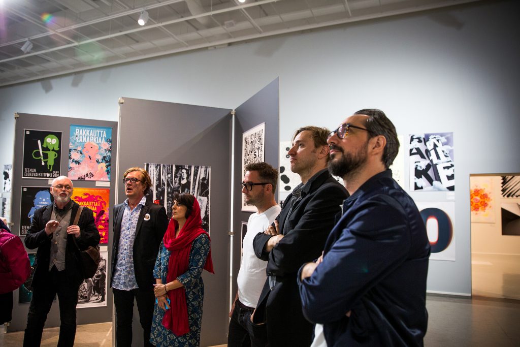 People standing in a row staring to the same direction.