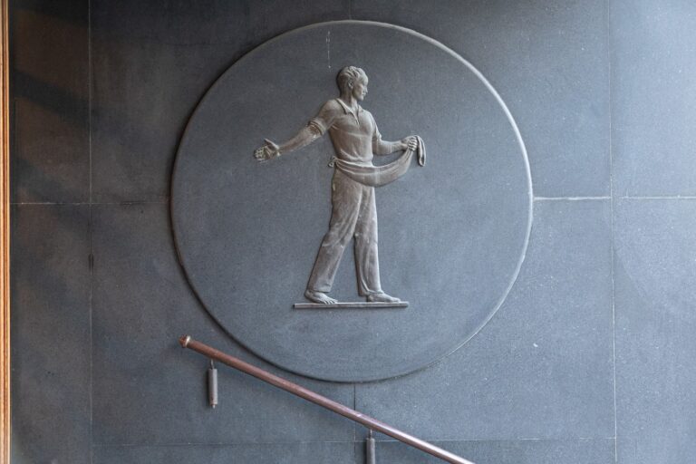 Reliefi, jossa paljasjalkainen mieshahmo pitää toisella kädellään lanteilleen kiedottua, jyvien kantamiseen käytettävää liinaa ojentaen kättään levittääkseen siemeniä.